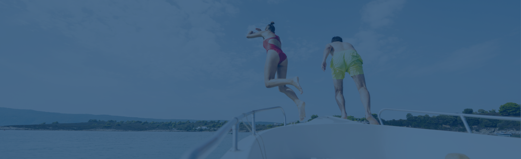 two people jumping into water off the bow of a boat