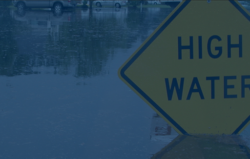 high water sign in flooded neighborhood