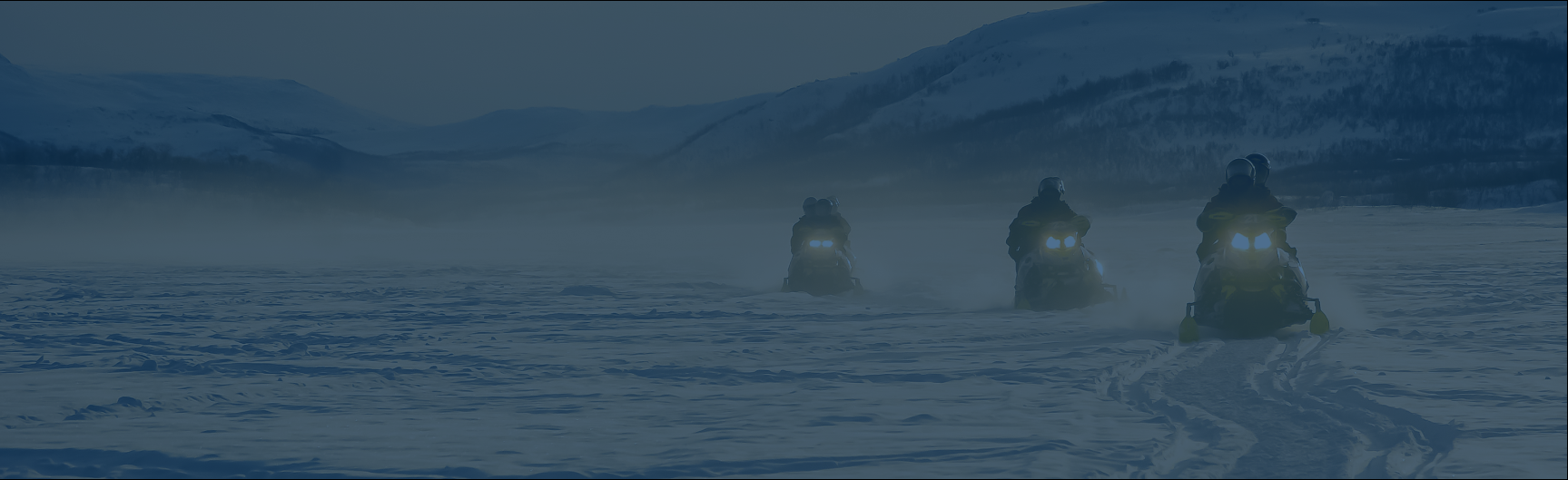 group of people riding snowmobiles